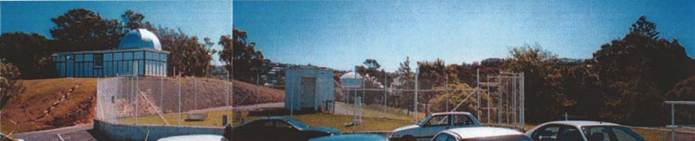 A white building with a basketball hoop and trees in the backgroundAI-generated content may be incorrect.